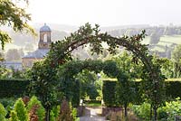 Malus domestica 'Katy' planted over an arch in the kitchen garden at Chatsworth. Other names - Apple 'Katy', Apple 'Katya', Apple 'Katja'