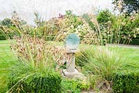 Chrysalis by Marzia Colonna, surrounded by Stipa gigantea in the centre of the lawn - Rhodds Farm, Kington, Herefordshire, UK