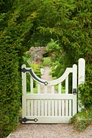 Gate into walled garden through yew hedge. Perrycroft, Upper Colwall, Herefordshire, UK