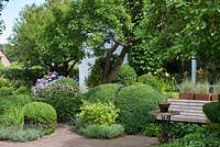 Terracotta brick path through border with Prunus cerasifera tree, Hydrangea, Buxus and Taxus balls and hedges, Anemone, Fern, Lavender and Iris - Ulla Molin 