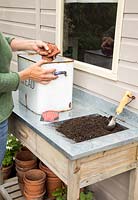 Step by Step -  Planting Carrot 'Sugarsnax' in a bread bin - adding crocks for drainage 