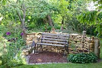 Rustic bench in front of stone wall