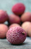 Litchi chinensis - Lychees on a wooden surface