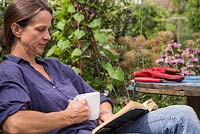 Female gardener reading in the garden