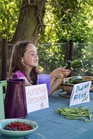 Young girl offering vegetables for sale