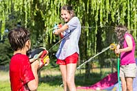 Children having a water fight in the garden