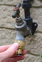 Outside tap being fitted with a hose connector