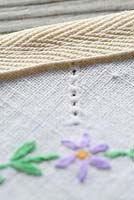 Step by step of making garden bunting with vintage linens and buttons - Detail of straight stitch along the top of the bunting