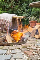 Firepit made from a dustbin lid with surrounding seating area