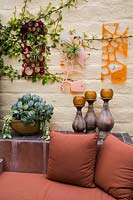 Outdoor living area with wall art and container of Ficus pumila, Kalanchoe marmorata, Sedum morganianum