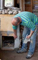 Man building a stone pizza oven