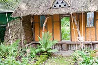 Decorative garden shelter made from wattle and daub and lime wash with mirrors to give a sense of extra space 