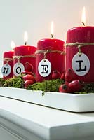 Christmas candle decorations spelling NOEL, made using Rose Hips and moss