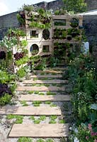 Vertical garden from pallets planted with Lettuce green oakleaf, Rosmarinus, Salvia, Origanum, thymus and menthe varieties.