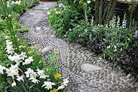 Pebble paved path and flowering borders in the Get Well Soon garden