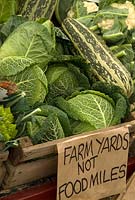 Vegetables on market stall, with green message about food miles