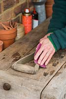 Sanding down wooden parts of spade to remove any splinters and prepare for oiling