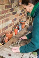Sanding down wooden parts of spade to remove any splinters and prepare for oiling