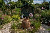 Arbour seat and garden urn in the gravel garden, Bens acre, West Sussex, owned and designed by Pauline Clarke