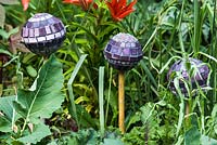 Mosaic balls on sticks, designed by Anne Cardwell, in the border with Lilies in Helen Riches town garden, June