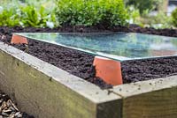 Warming soil using terracotta pots and a sheet of glass