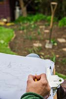 Woman sat in deck chair garden planning