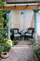 Outdoor seating area with netted curtain.