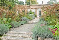 Path lined with lavender, sedums and crab apples line the path leading to the Orangery. Mapperton House, Beaminster, Dorset, UK