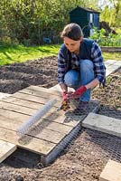 Cutting section of chicken wire. 