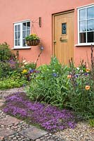 Front garden with Thyme in gravel and pots by front door