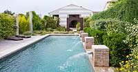 Modern contemporary garden - decking, metal 'oculus' circle and swimming pool with four brick water spouts. Les Confines, Provence, France