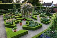 Aerial view of parterre garden with romantic English traditional style with layout of box hedging infilled with peonies and a central arbour covered with climbing rose - Seend, Wiltshire