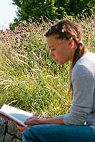 Woman reading surrounded by wildflowers of Centaurea jacea and Knautia arvensis
