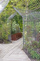 Title: Les Fleurs Maudites. Timber walkway with metal fences and frames and rusty bench