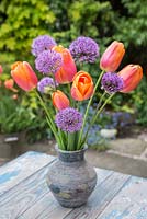 Floral display of Tulipa 'Prinses Irene' and Allium hollandicum 'Purple Sensation' in a jug