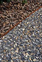 Flint gravel pathway and Fircone 'mulch' - The Flintknapper's Garden-A Story of Thetford. Designer: Luke Heydon. Sponsors: Businesses in and around Thetford - RHS Hampton Court Palace Flower Show 2014 