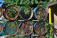 A Space To Connect and Grow. Screen using stacked decorated half cut reclaimed metal drums, wildlife wall, insect hotel
