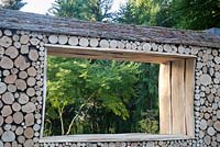 Green is the Colour - view of log wall and insect bug houses hotel - Designer - Elinor Scarth and Etienne Haller - Sponsor - The RHS
