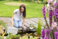 Young girl pond dipping in her garden