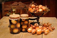 Rustic country kitchen scene with home made jars of pickled onions, pickling onions and traditional kitchen scales