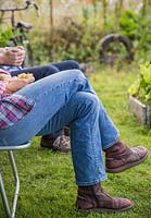 Man and woman sat in deck chairs at an allotment plot