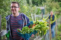 Man and woman leaving an allotment carrying their produce with them
