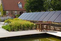 A solar panel installation in a garden setting. August, Summer 2014.