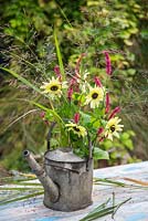Floral display of Helianthus, Persicaria and Eragrostis spectabilis - Lovegrass in a watering can