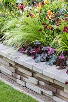 Raised bed containing Heuchera 'Black Beauty', Stipa tenuissima, Cosmos atrosanguineus, Dahlia 'Jescot Julie' and Hemerocallis 'Black Stockings'. Garden: Bacchus Garden. RHS Hampton Court Flower Show 2014