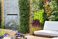 Chairs with cushions on decking. RHS Hampton Court Flower Show 2014, Design: Ian Hammond