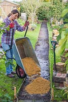 Fill the new path with an equal distribution of a coarse grit sand. This will need to be a 2 inch layer of sand. 