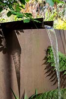 Iron rill with waterfall in town garden, Brixton