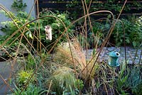 Town garden, Brixton, with details of raised beds with mixed planting of vegetables and grasses and building rods used as plant supports