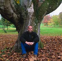 Stephen Lloyd, head gardener, having worked at Hergest Croft since 1984. Resting against trunk of old Acer platanoides 'Schwedleri'